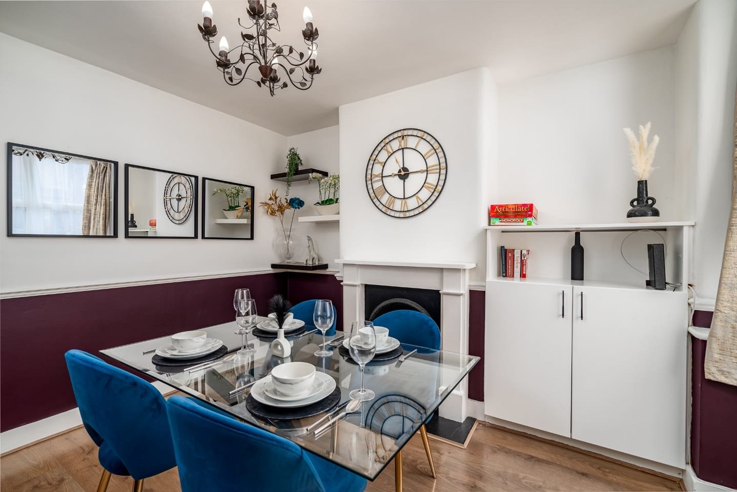 A furnished dining room with blue velvet chairs and a glass table in a Watford property managed by Rethinking Property